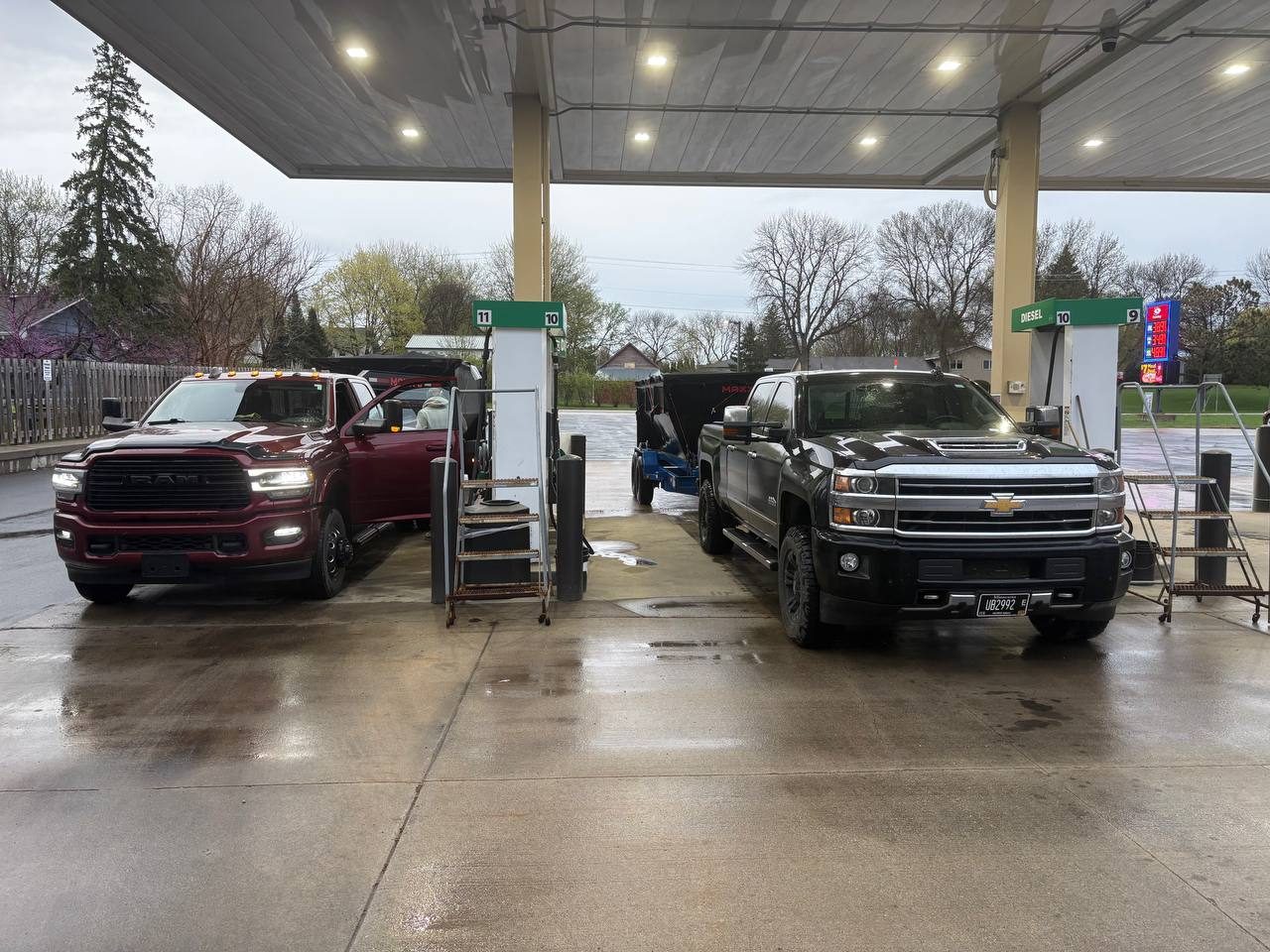 Twin Cities Concrete Demolition fleet — Ram 3500 and Chevy Silverado HD trucks fueling up with roll-off dumpster trailer in Carver County, Minnesota