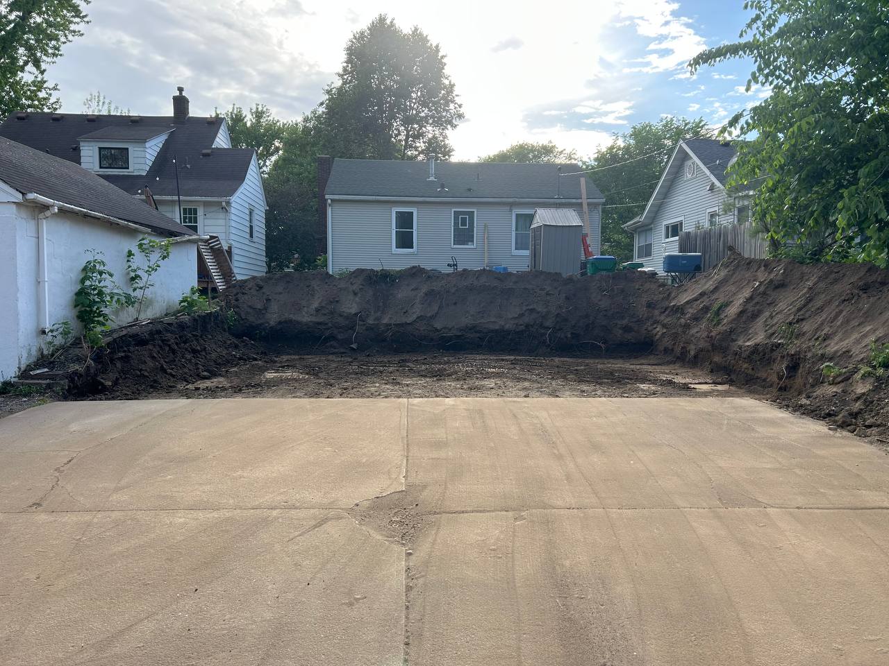 Backyard concrete pad exposed after retaining wall removal, Twin Cities