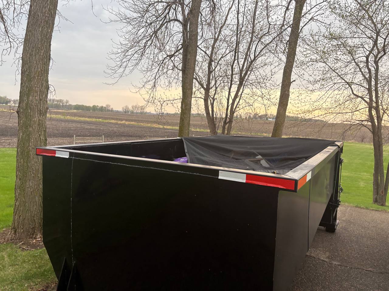 Twin Cities Concrete Demolition roll-off dumpster rental with tarp net cover, rural Minnesota