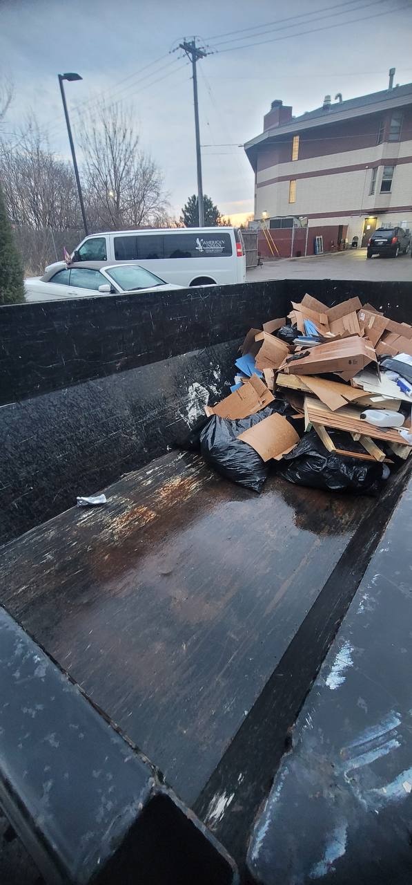 Dump trailer loaded with cardboard, wood, and debris from commercial cleanup job, Twin Cities